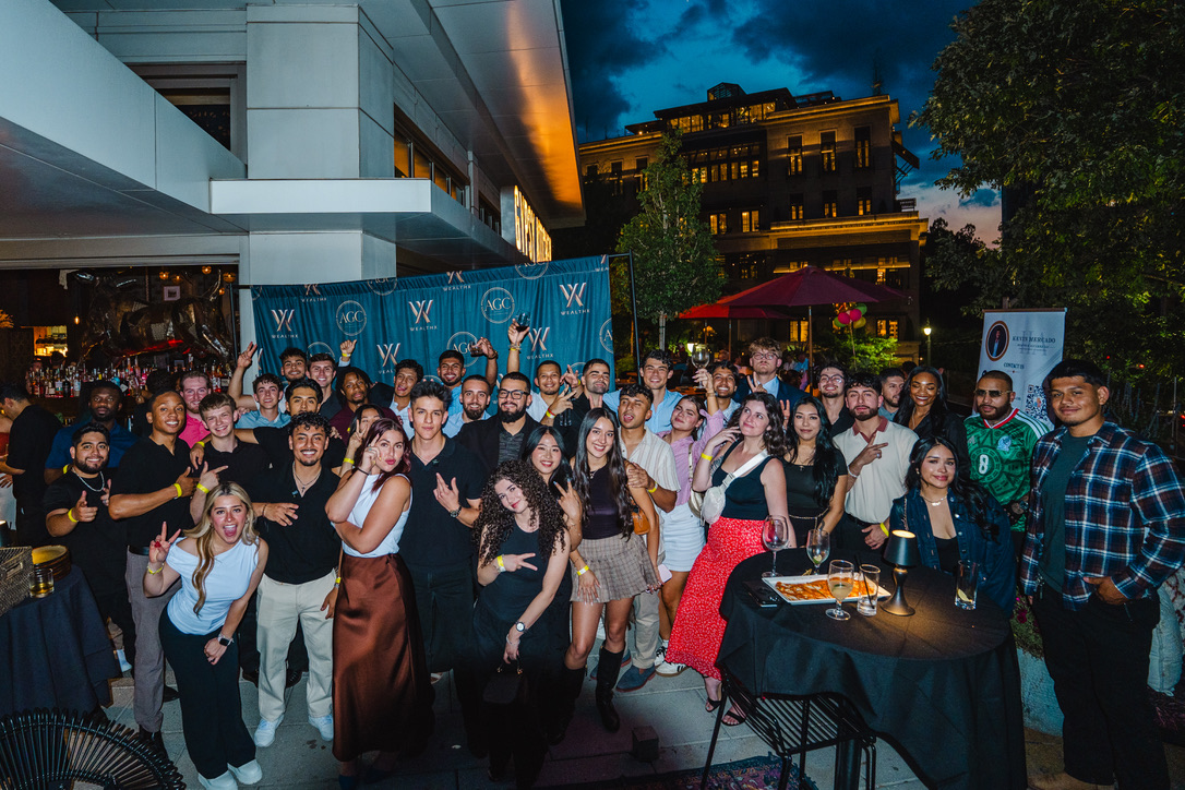 A large WealthX ATL community gathering outdoors at night